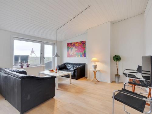 een woonkamer met een bank en een tafel bij Apartment Meglena - 50m from the sea in NW Jutland by Interhome in Løkken