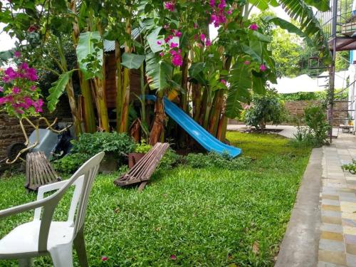 um parque infantil com um escorrega num quintal em Cozy studio with lovely garden em Tigre