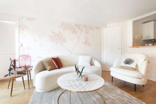 uma sala de estar com um sofá branco e uma mesa em 123paris city em Paris