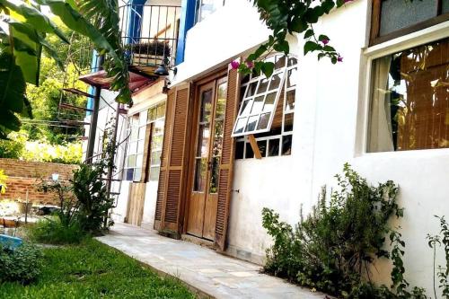 uma casa com uma porta de madeira num quintal em Cozy studio with lovely garden em Tigre