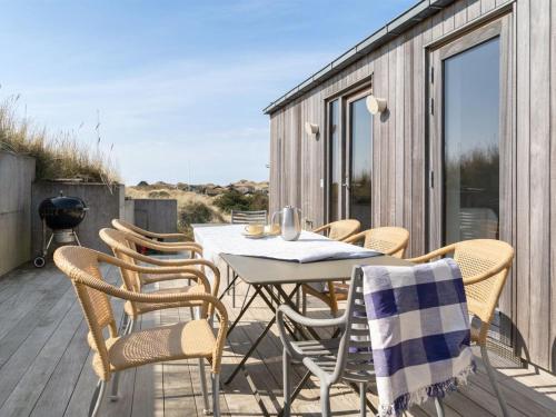 ブロックフスにあるHoliday Home Silvette - 400m from the sea in NW Jutland by Interhomeのデッキにテーブルと椅子が置かれたパティオ