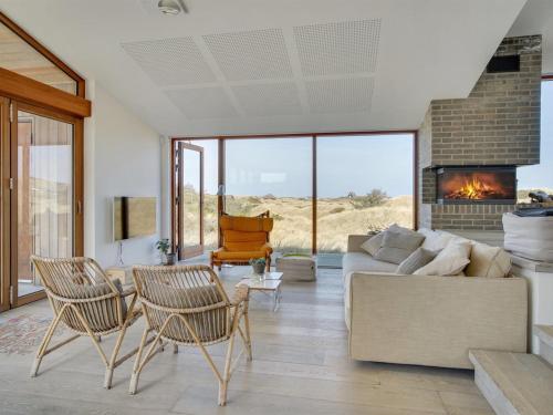 ブロックフスにあるHoliday Home Silvette - 400m from the sea in NW Jutland by Interhomeのソファと椅子と暖炉のあるリビングルーム