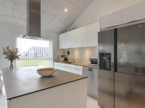 a kitchen with white cabinets and a bowl on a counter at Holiday Home Dwerg - 1-5km from the sea in NW Jutland by Interhome in Løkken