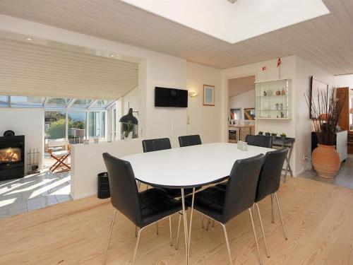 a dining room and living room with a table and chairs at Holiday Home Frethi - 350m from the sea by Interhome in Blokhus