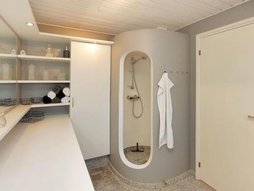 a bathroom with a shower and a mirror at Holiday Home Frethi - 350m from the sea by Interhome in Blokhus