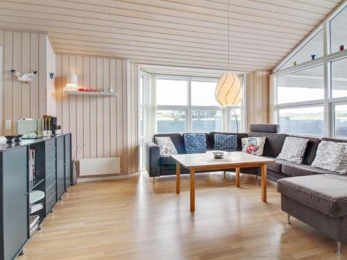 een woonkamer met een bank en een tafel bij Holiday Home Anett - 400m from the sea in NW Jutland by Interhome in Løkken
