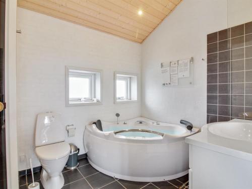 een badkamer met een bad, een toilet en een wastafel bij Holiday Home Anett - 400m from the sea in NW Jutland by Interhome in Løkken