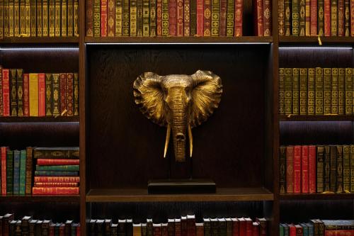 a statue of an elephant on a shelf with books at Aldwark Manor Estate in Aldwark