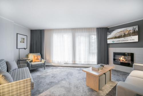 a living room with a couch and a fireplace at Lake Louise Inn in Lake Louise