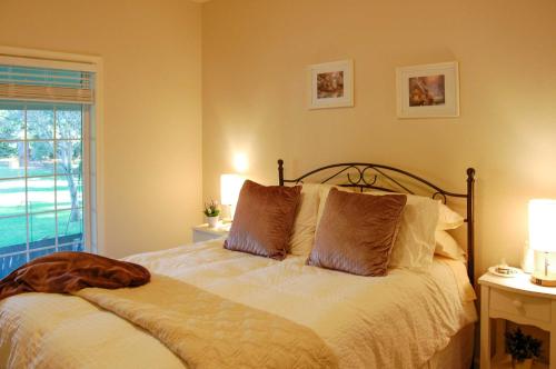 a bedroom with a bed with white sheets and a window at McMinnville Wine Country Home with Hot Tub and Deck in McMinnville