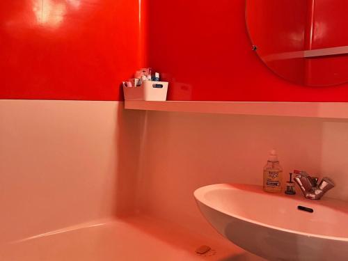 łazienka z umywalką i czerwoną ścianą w obiekcie Studio rénové 4 pers · Pied des pistes · Balcon Sud-Ouest · Wifi gratuit · Proche commerces - FR-1-346-550 w mieście Arc 1800