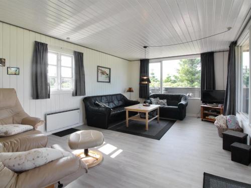 a living room with a couch and a table at Holiday Home Demus - 900m from the sea in NW Jutland by Interhome in Løkken