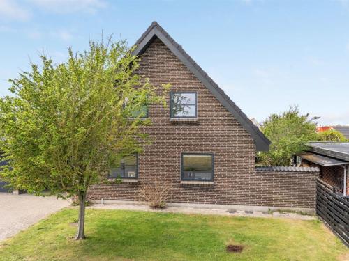 a brick house with a clock on the side of it at Holiday Home Gudlaug - 400m from the sea in NW Jutland by Interhome in Blokhus