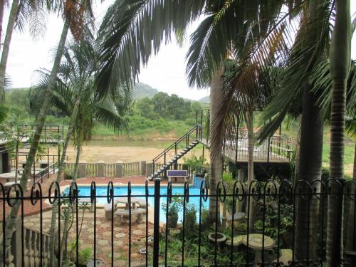 a view of a pool from behind a fence at Belvedere-on-River in Malelane