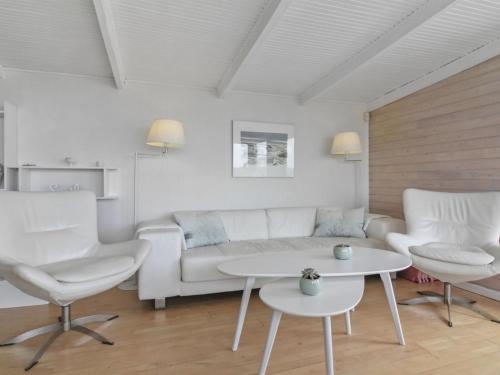 洛肯的住宿－Holiday Home Franja - 100m from the sea in NW Jutland by Interhome，客厅配有沙发、两把椅子和一张桌子