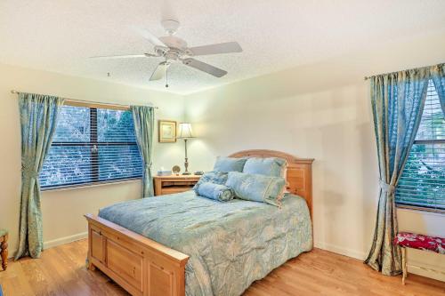a bedroom with a bed and a ceiling fan at Waterfront Port St Lucie Home with Lanai and Pool in Walton