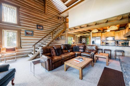 a living room with leather furniture in a log cabin at Temptation 8 condo in Park City