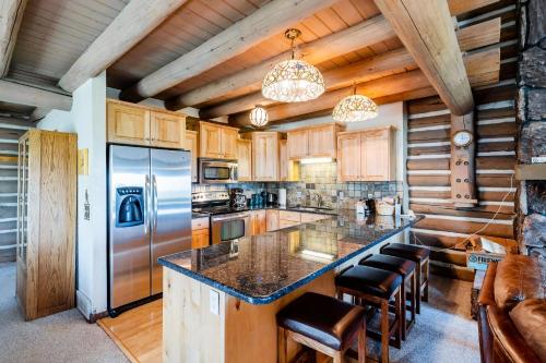 a kitchen with wooden cabinets and a large island with bar stools at Temptation 8 condo in Park City