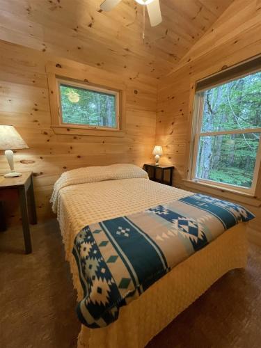 um quarto com uma cama num chalé de madeira em MAINE PINES LMIT 8 home em Denmark