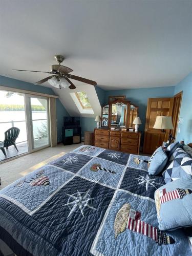 TREMONT LIMIT 10 villa في Bridgton: غرفة نوم بسرير ولحاف ازرق مع نجمه