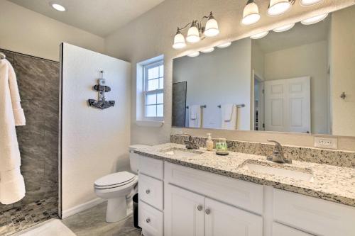 a bathroom with a sink and a toilet and a mirror at Canalside Crystal River Home with Dock and Kayaks in Crystal River