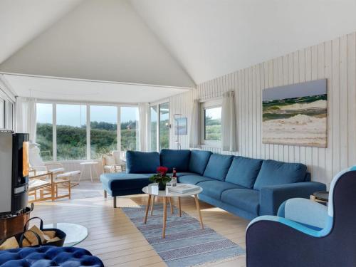 a living room with a blue couch and a table at Holiday Home Henric - 100m from the sea by Interhome in Blokhus