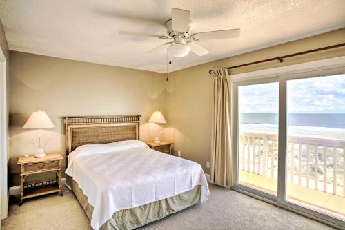 a bedroom with a bed and a balcony with the ocean at Bright Fernandina Beach Townhome Walk to Ocean! in Fernandina Beach