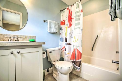 a bathroom with a toilet and a sink and a mirror at Bright Fernandina Beach Townhome Walk to Ocean! in Fernandina Beach