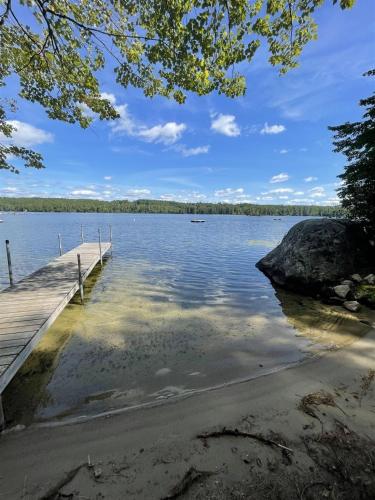 a dock on a lake with a rock at HIGHLAND HOLIDAY LIMIT 7-10 cottage in Bridgton