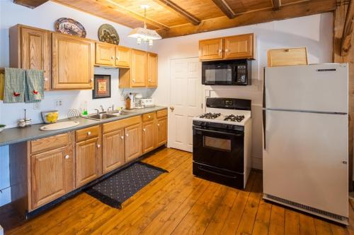 a kitchen with a white refrigerator and wooden cabinets at BOVE COTTAGE 2-LIMIT 6 cottage in Naples