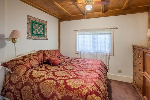 Naples的住宿－BOVE COTTAGE 2-LIMIT 6 cottage，一间卧室设有红色的床和窗户。