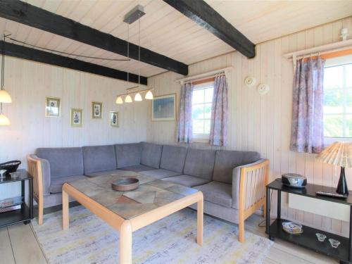 een woonkamer met een bank en een tafel bij Holiday Home Arita - 250m from the sea in NW Jutland by Interhome in Saltum