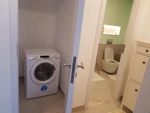 a bathroom with a washing machine and a toilet at Stylish 1 Bedroom Apartment Near Burj Al Arab (Madinat Jumeirah) in Dubai