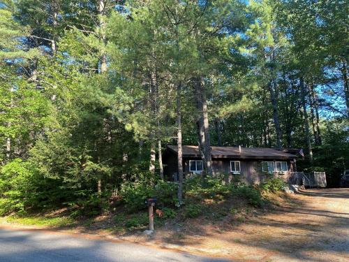 a small cabin in the woods next to a road at ALPINE VILLAGE GETAWAY LIMIT 8 cottage in Bridgton