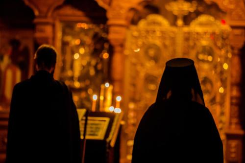 a man and woman standing in front of a church with candles at Valamon Luostari in Uusi-Valamo