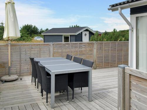 a patio with a table and chairs on a deck at Holiday Home Liisi - 500m from the sea in NW Jutland by Interhome in Hjørring