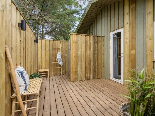 una terraza de madera con una silla y una valla en Holiday Home Ayelen - 600m from the sea in NW Jutland by Interhome en Saltum