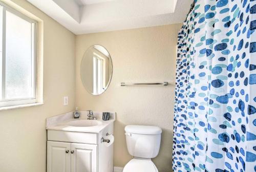 a bathroom with a toilet and a sink and a mirror at Sunny Indian Rocks Beach Condo Steps to Gulf! in Clearwater Beach
