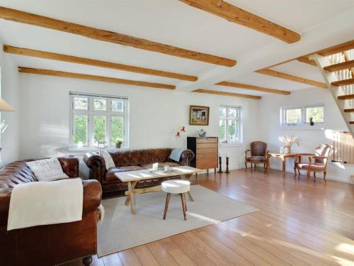 uma sala de estar com mobiliário de couro e tectos em madeira em Holiday Home Iara - 6km from the sea in NW Jutland by Interhome em Bindslev