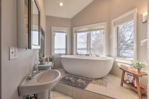 uma casa de banho com uma grande banheira branca e um lavatório. em Rhode Island Retreat with Kayaks, Deck and Pond Access em South Kingstown