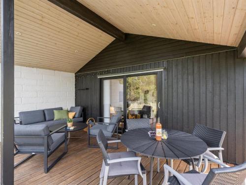 a patio with a table and chairs and a couch at Holiday Home Kadife - 750m from the sea in NW Jutland by Interhome in Saltum