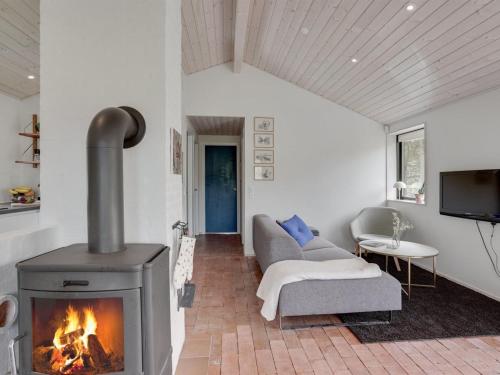a living room with a fireplace and a couch at Holiday Home Kadife - 750m from the sea in NW Jutland by Interhome in Saltum