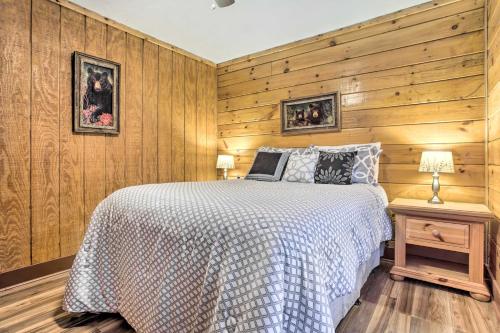 een slaapkamer met een bed en een houten muur bij Turkey Creek Cove Cabin in Clyde with Gas Grill! in Clyde