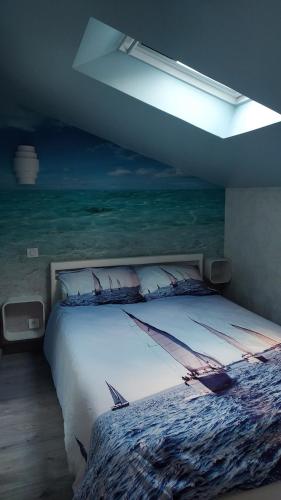 - une chambre avec un lit orné d'une peinture sur l'océan dans l'établissement Maison coup de coeur, à Marseillan