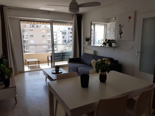 un salon avec une table et un canapé dans l'établissement Charmant 2 pièces balcon vue mer, à Vallauris