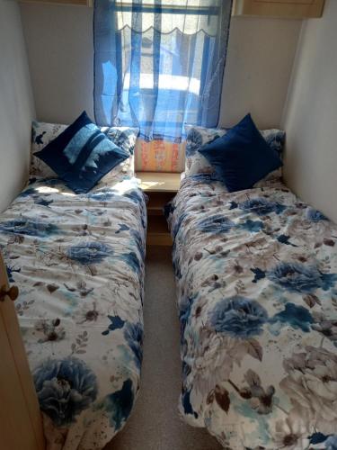 um pequeno quarto com 2 camas e uma janela em Holiday Home em Forfar