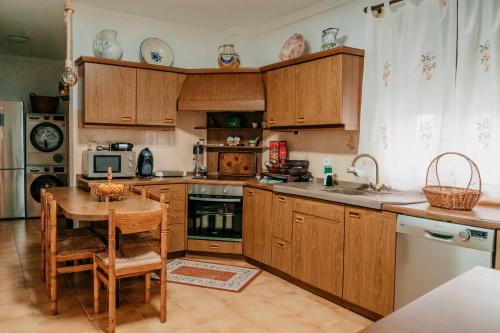 a kitchen with wooden cabinets and a wooden table and a tableablish at Casa Capricho del Destino in Villatobas