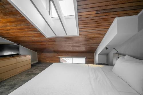 a bedroom with a large white bed and a skylight at Lake Louise Inn in Lake Louise
