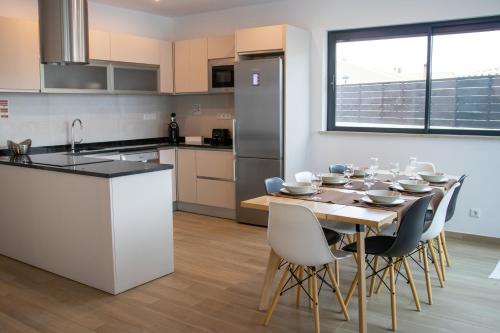 a kitchen and dining room with a table and chairs at Sunrise Villa in Sagres