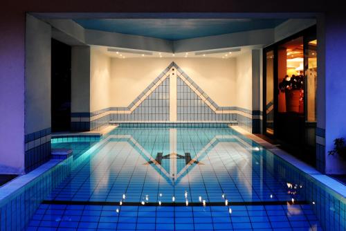a swimming pool in a building with lights on it at Hotel Ambassador in Riccione